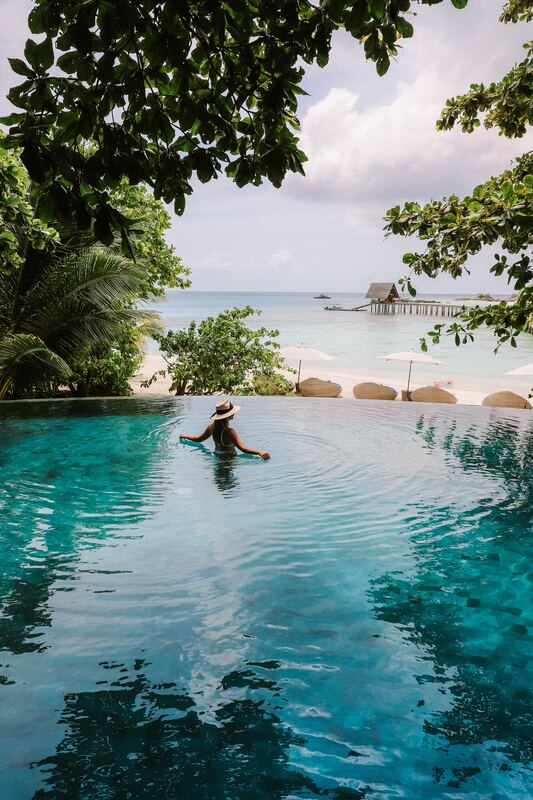 Woman in tropical resort infinity pool